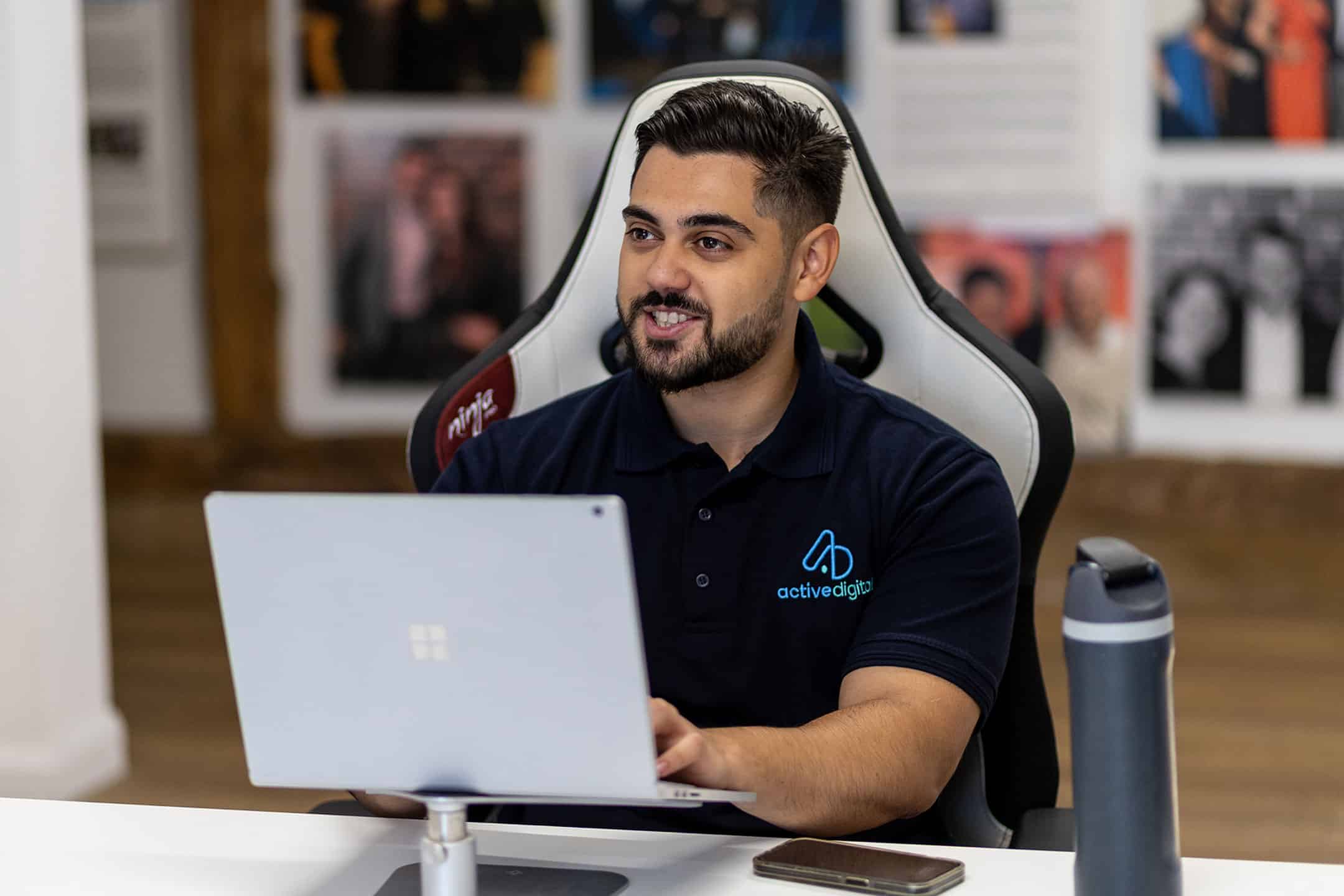 Support specialist working at desk with laptop and headset.