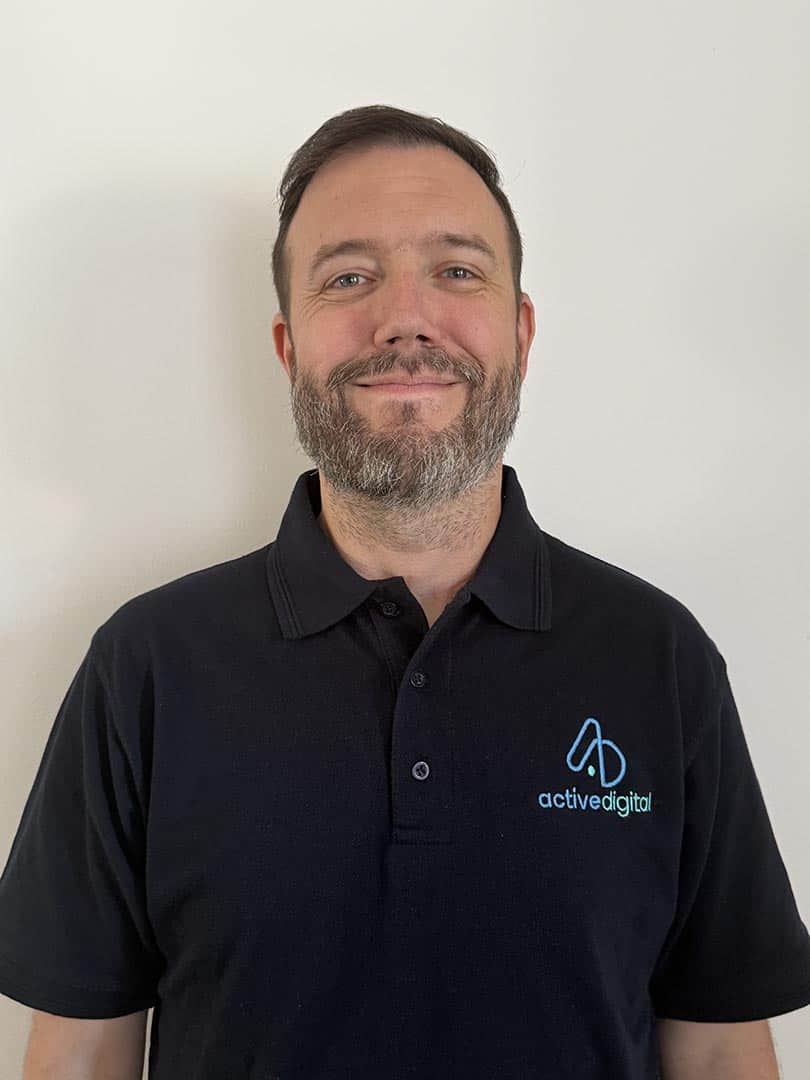 Smiling man in Active Digital polo shirt against white background.