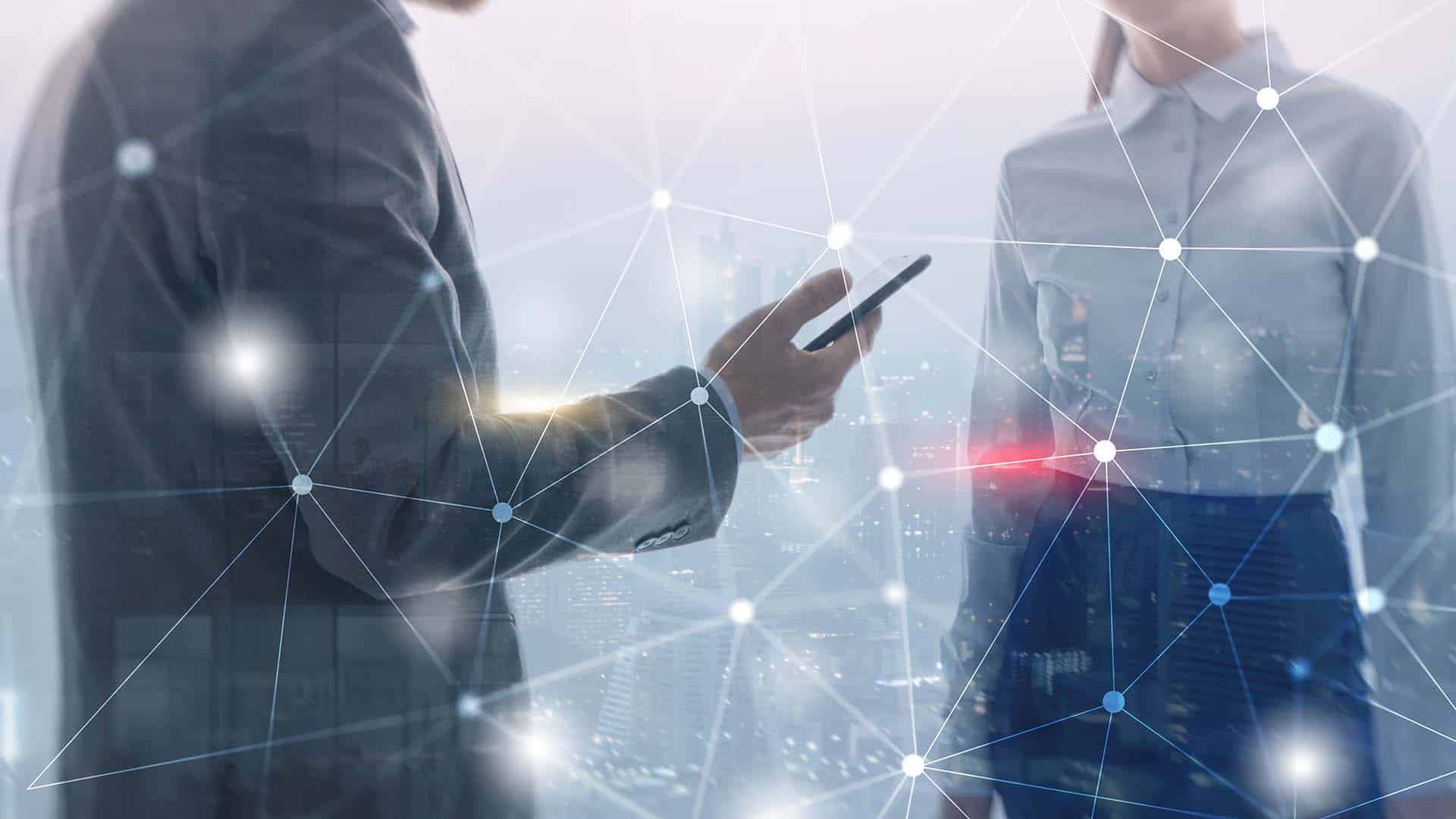Business professionals using a smartphone with digital network overlay.