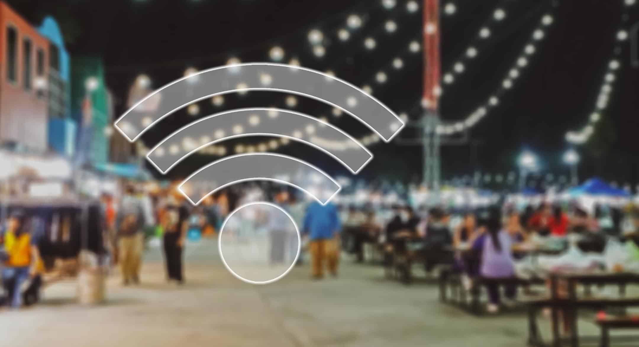 WiFi signal icon over busy night market scene in UK.