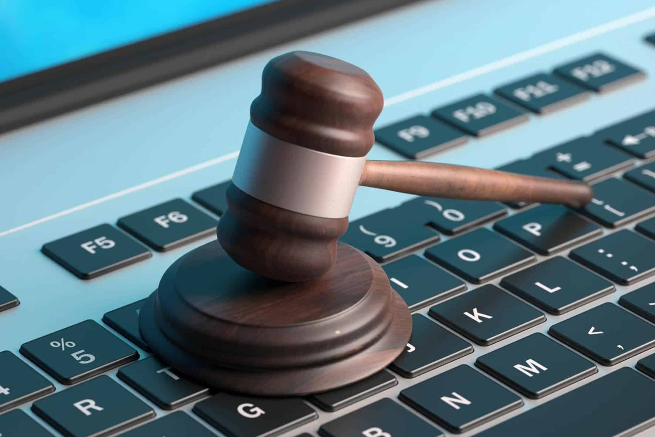 Gavel on a keyboard representing legal and compliance issues in digital services.