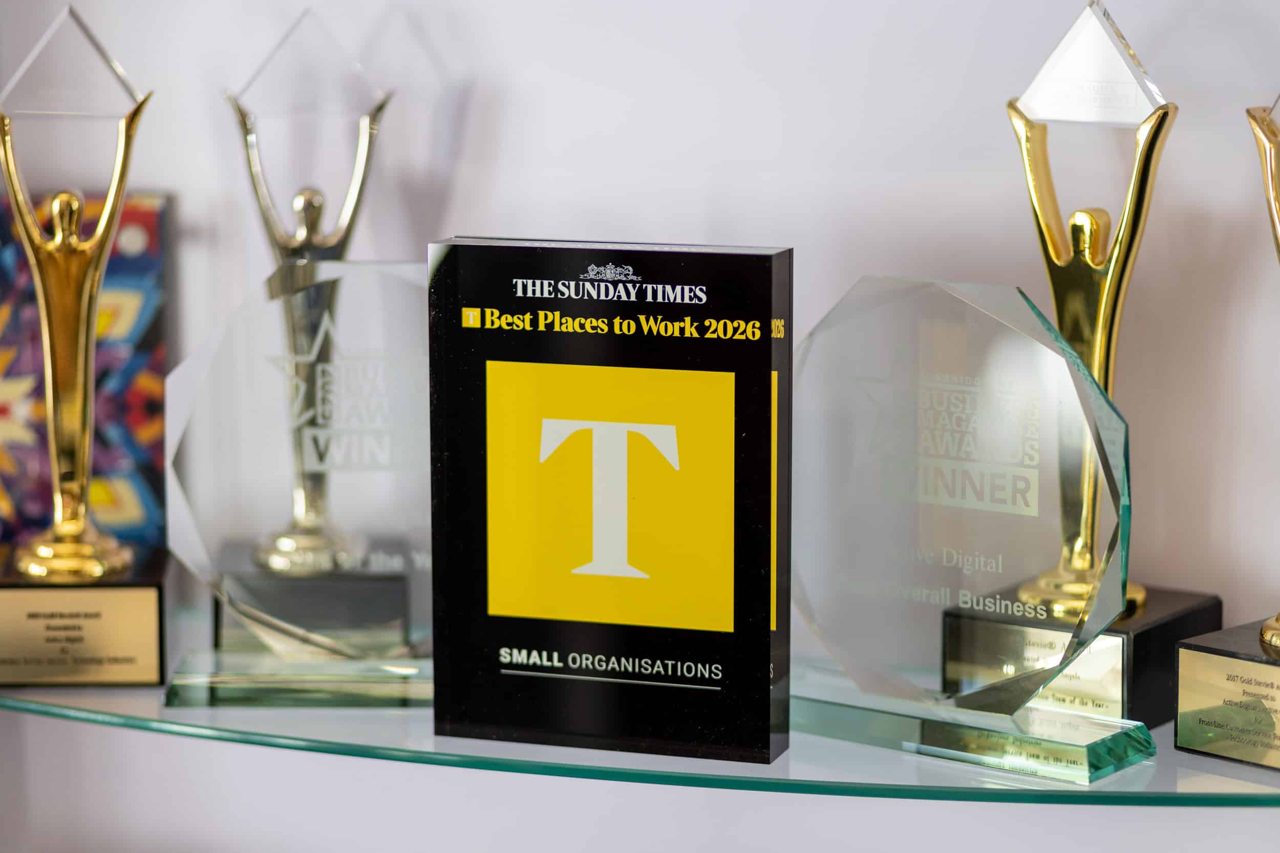 Collection of awards and trophies including 'Best Places to Work 2026'.